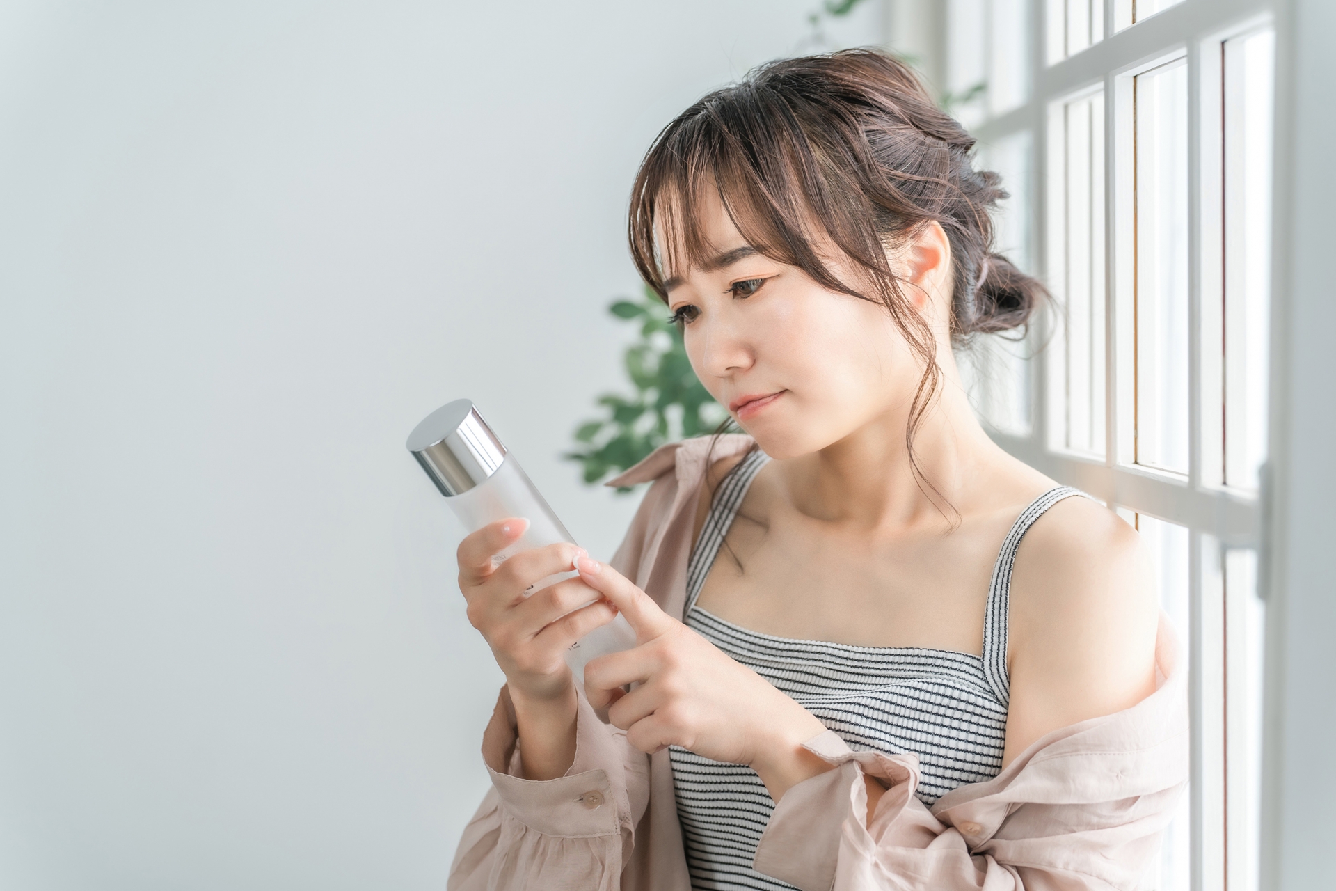 化粧品の成分ラベルを読み解く女性のイメージ